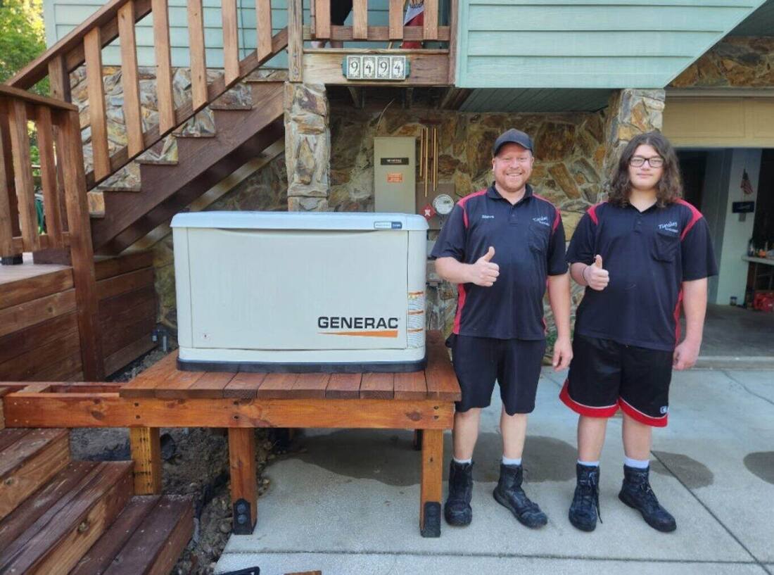 Two Tinsley Electric team members beside a newly installed Generac home standby generator