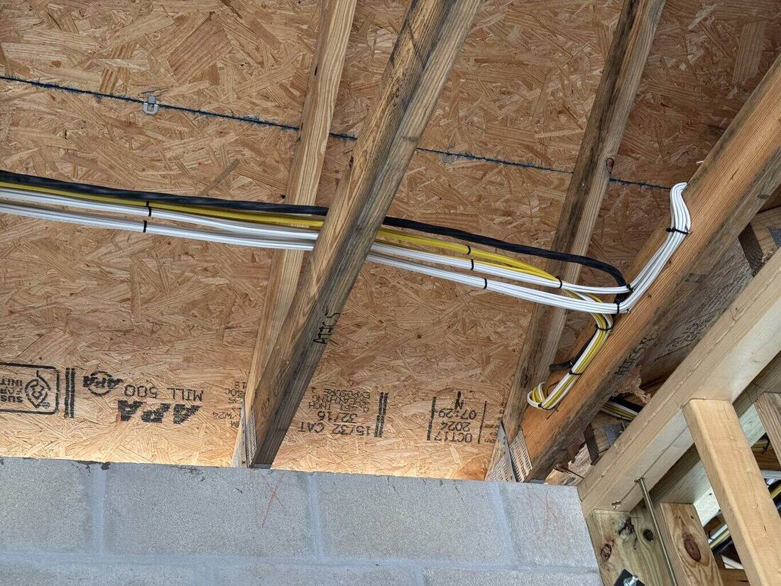 Conduit and cable runs along ceiling framing